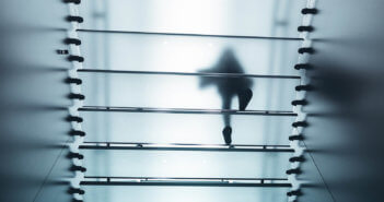 Person walking up a translucent staircase