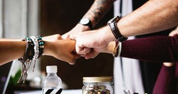 Group fist bump from the outstretched arms of a diverse group of young adults