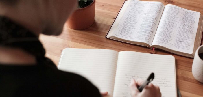 Pastor working a sermon with an open Bible and notepad on the desk