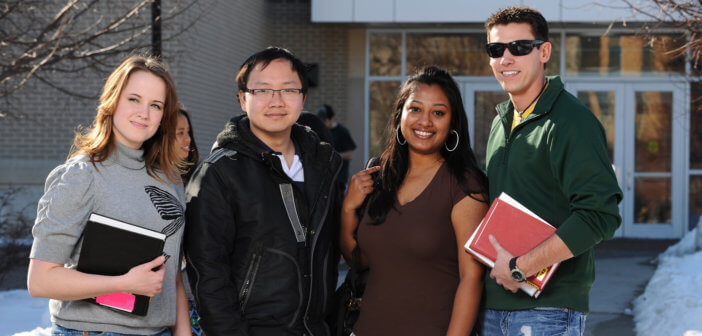 Group of diverse students standing in front of a suburban high school