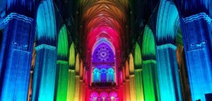 Interior of a church lit in rainbow hues
