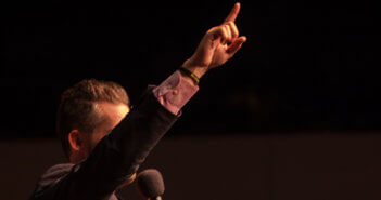 Pastor with their index finger in the air
