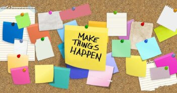 Cork board full of thumbtacked notes including a big one that says MAKE THINGS HAPPEN!