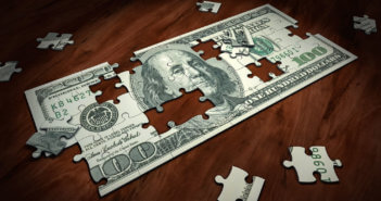 Jigsaw puzzle in the shape of a $100 bill