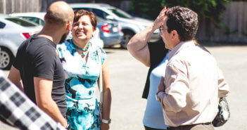 Folks having a friendly conversation in the church parking lot