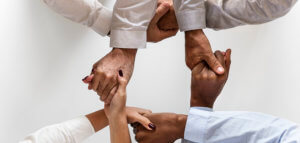 Diverse group of people clasping hands together