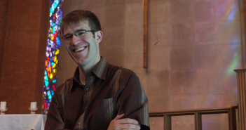 Smiling pastor standing at the chancel