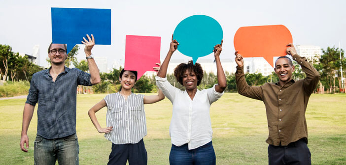 Four millennials holding up cardboard speech bubbles