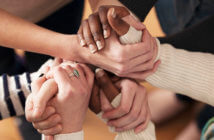 5 Key Practices for Building a High-Trust Culture Close up of a group of people's hands clasped together