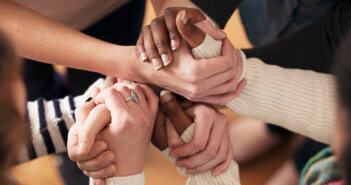 Close up of a group of people's hands clasped together