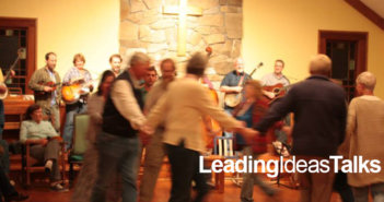 People whirling in a circle to live bluegrass music at a square dance at Wild Goose Christian Community