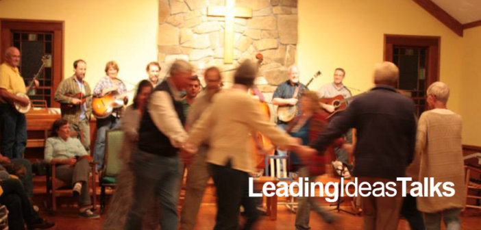 People whirling in a circle to live bluegrass music at a square dance at Wild Goose Christian Community