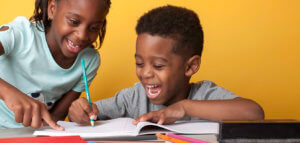 Smiling kids writing in a notebook