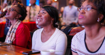 Engaged young adults at a worship service sitting at a table with their cellphones before them -- Photographer: Matt Anderson 2015