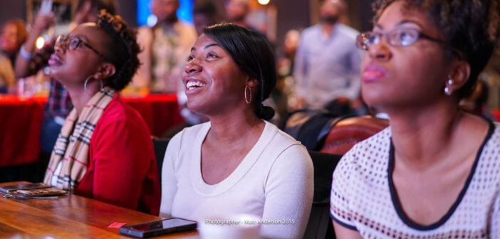 Engaged young adults at a worship service sitting at a table with their cellphones before them -- Photographer: Matt Anderson 2015