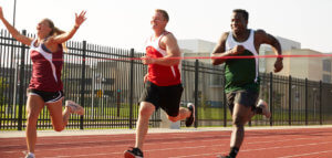 Runner surging ahead to cross the finish line ahead of other runners in a race