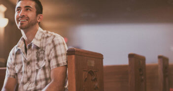 Smiling, attentive person sitting in a pew