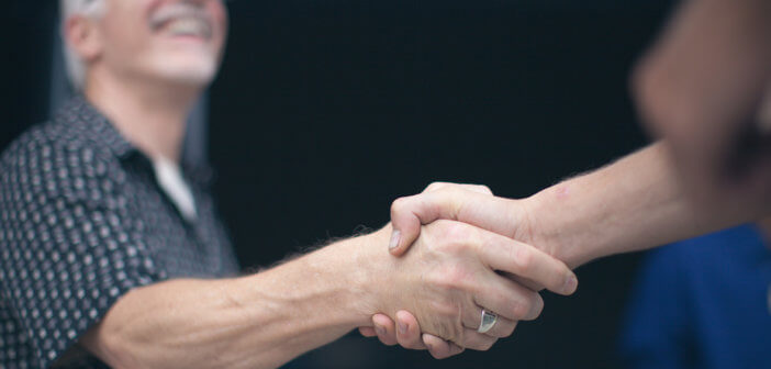 Person warmly shaking hands with another