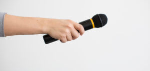Hand passing a microphone to someone for an introduction