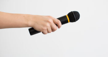 Hand passing a microphone to someone for an introduction