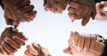 Hands of people of difference races clasped together