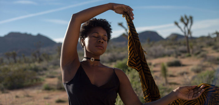 Person with closed eyes meditating in the desert