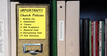 7 Policies Every Church Needs for Trust and Transparency Bookshelf with binder of church policies