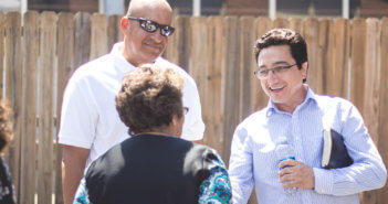 Pastor and church member outside speaking with a community member