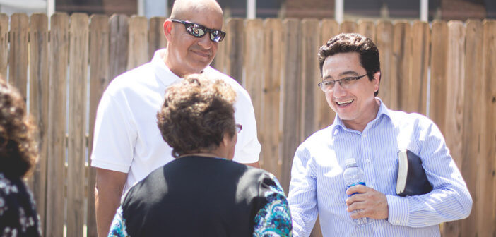 Pastor and church member outside speaking with a community member