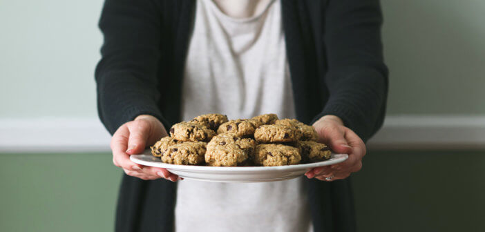 Person offering a plate of delicious cookies