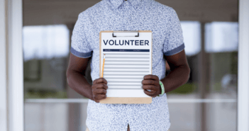 Person holding a volunteer sign-up sheet