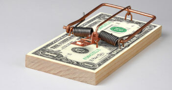 Mouse trap on a stack of cash bills