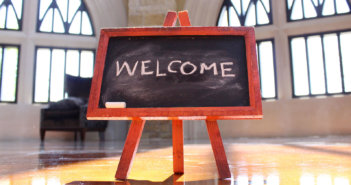 Easel with WELCOME written in chalk in a church sanctuary
