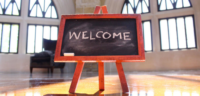 Easel with WELCOME written in chalk in a church sanctuary