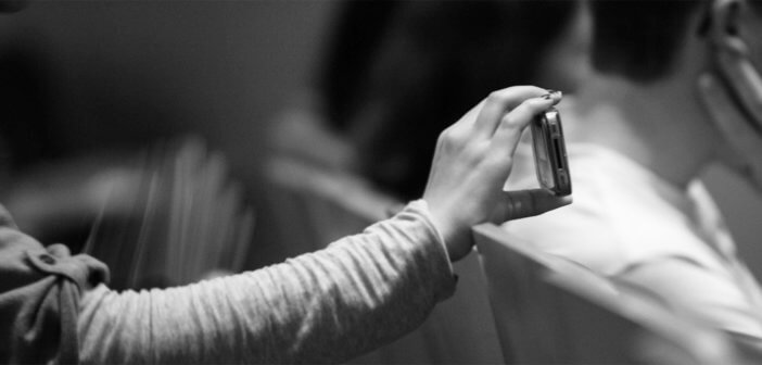 Person filming worship on a mobile phone