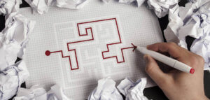Person working successfully through a maze on pen and paper