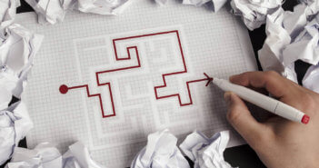 Person working successfully through a maze on pen and paper
