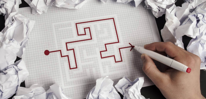 Person working successfully through a maze on pen and paper