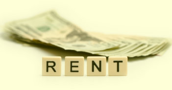 Before You Rent Church Space, Calculate the Costs R E N T spelled out on tiles in front of a stack of cash