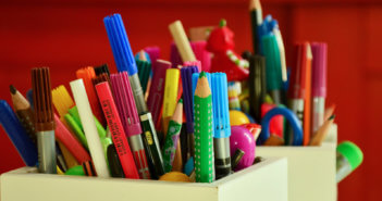 Box overflowing with colored pencils and markers