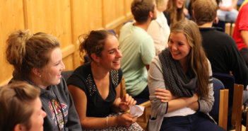 Smiling groups of younger adults engaged in animated conversations