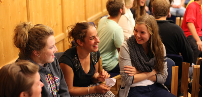 Smiling groups of younger adults engaged in animated conversations