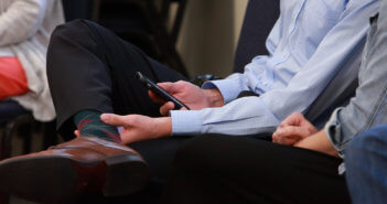 Person sitting in a worship service using their smartphone