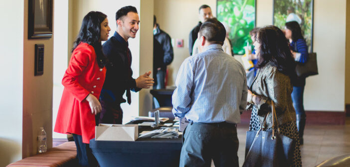 Friendly volunteers at a church information table chatting with other church members