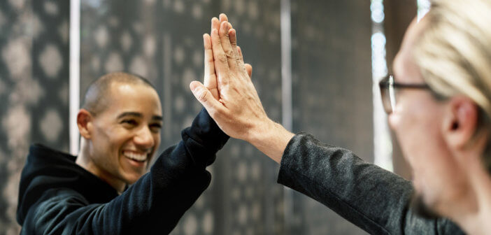 Smiling people giving each other a high five