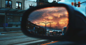 View from the passenger seat of a car of the driver's side mirror