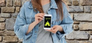 Young adult holding a cell phone that shows a donation to the church