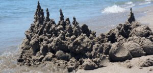 Sand castle being eroded by waves