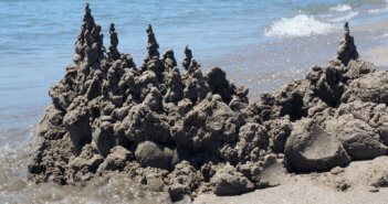 Sand castle being eroded by waves