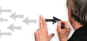 Person drawing arrows going forward in contrast to arrows going backward